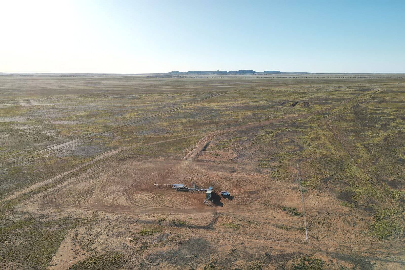 A small containerised mining installation alone on a vast, flat outback plain in the Cooper Basin.